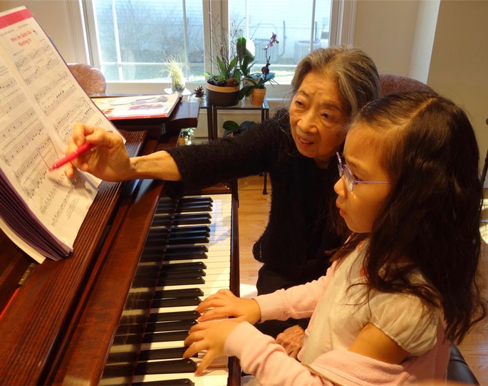 Hanna giving granddaughter Noemi a piano lesson